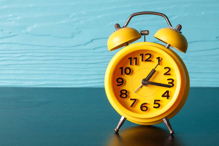 yellow clock on blue background representing puppy potty schedules